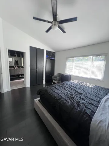 a spacious bedroom with a bed and wooden floor