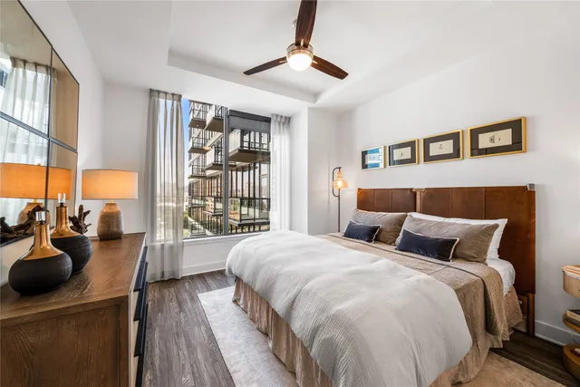 a bedroom with a bed a couch and a large window