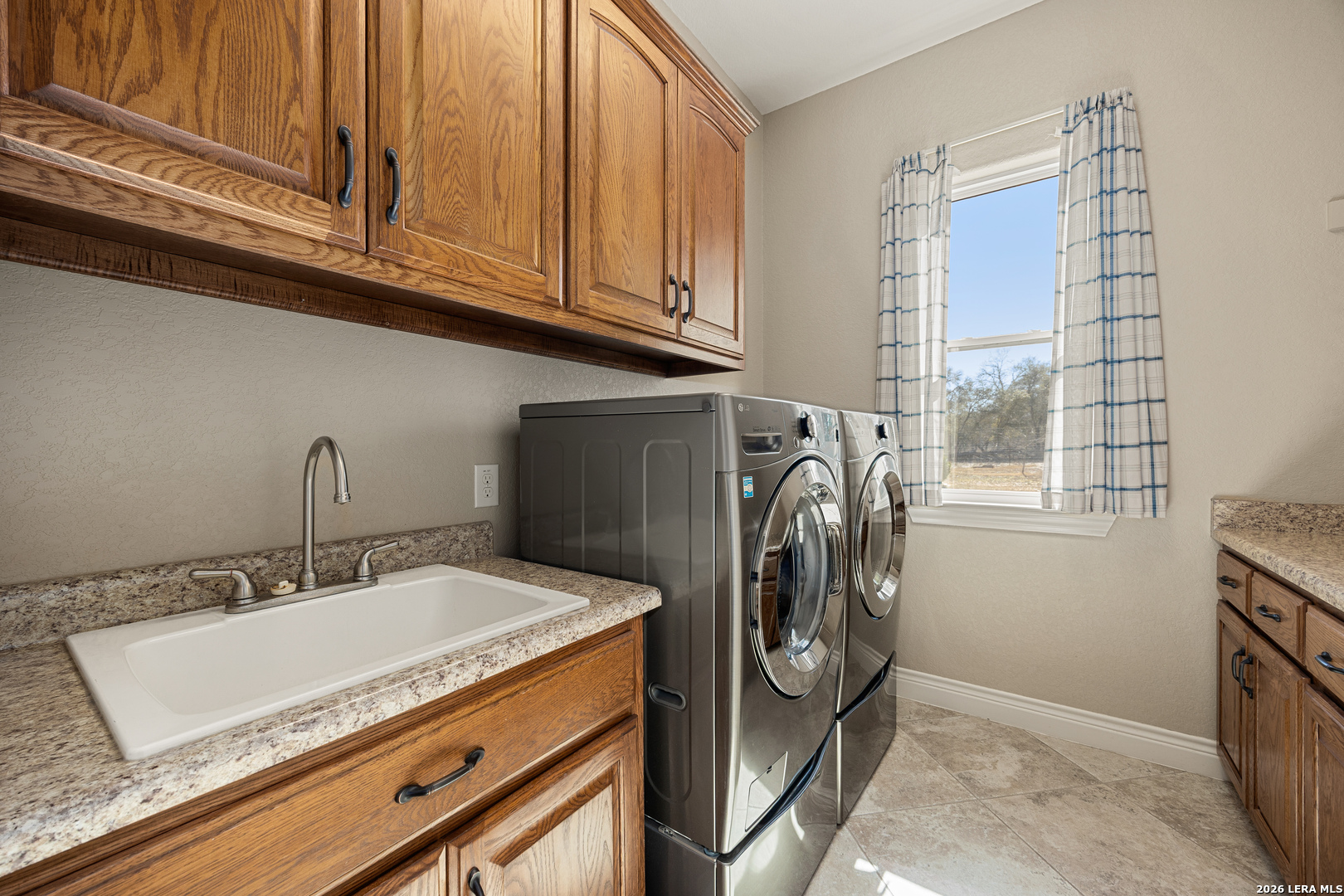 133 Vintage Ranch Circle La Vernia, TX 78121 - Photo 20 of 48 a utility room with stainless steel appliances granite countertop a sink and a washer dryer