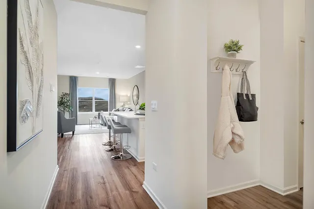 a view of a hallway with wooden floor and furniture