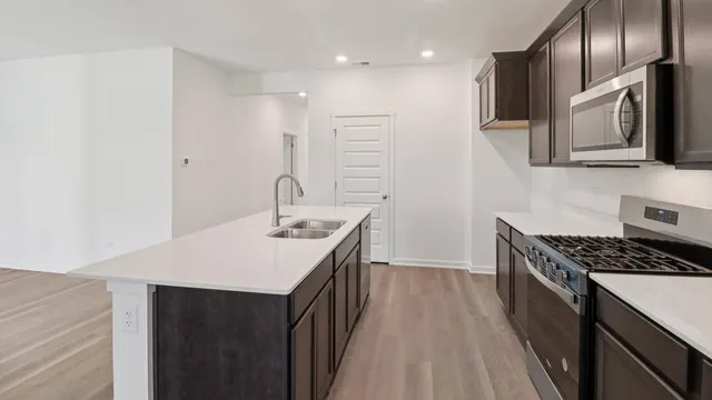 a kitchen with a sink a microwave and cabinets
