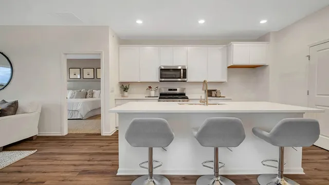 a kitchen with kitchen island a stove a table and chairs in it