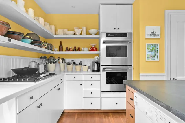 a kitchen with granite countertop a stove a sink and a microwave