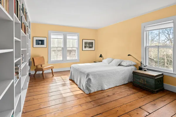a bedroom with a bed and wooden floor