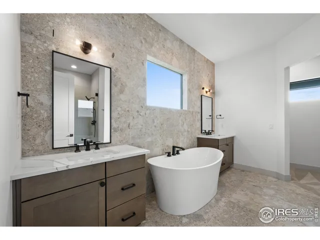 a bathroom with a white bath tub a sink and mirror