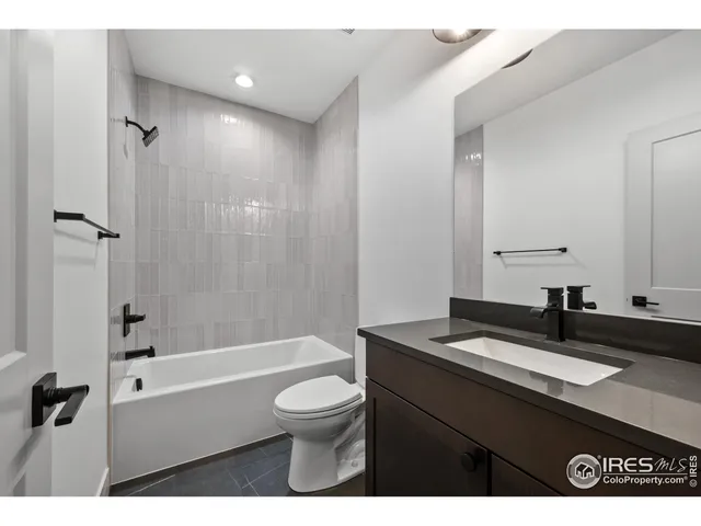 a bathroom with a granite countertop sink toilet a mirror and shower