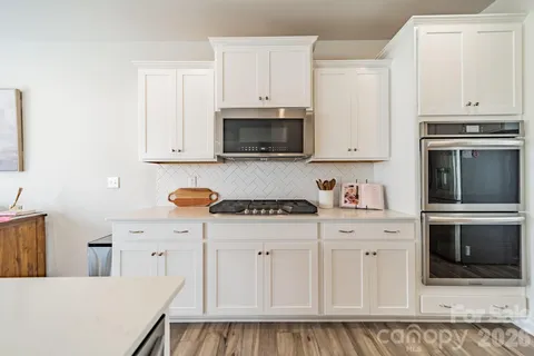 a kitchen with white cabinets and stainless steel appliances