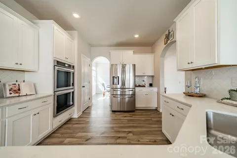a kitchen with white cabinets and stainless steel appliances
