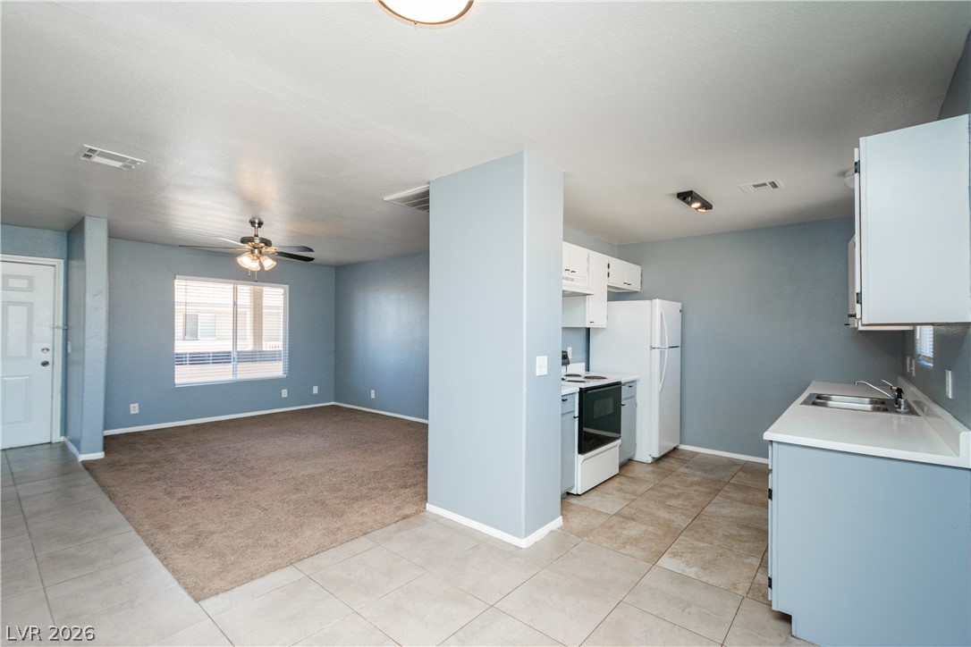 1444 Star Road Pahrump, NV 89048 - Photo 6 of 37 An open layout connects the tile-floored entry and kitchen directly to the carpeted living space.