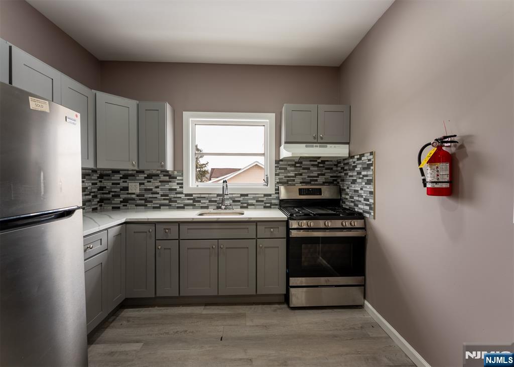 86 Hunter Street Lodi, NJ 07644 - Photo 2 of 18 a kitchen with stainless steel appliances granite countertop a stove a refrigerator and a sink