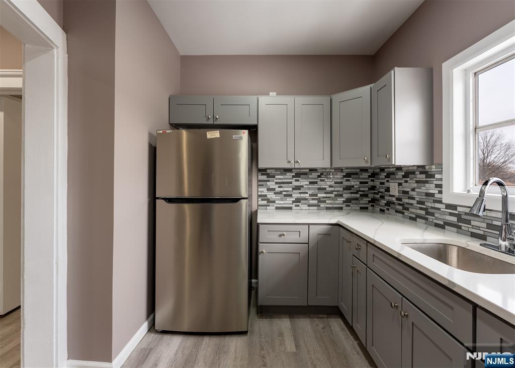 86 Hunter Street Lodi, NJ 07644 - Photo 3 of 18 a kitchen with a refrigerator sink and cabinets