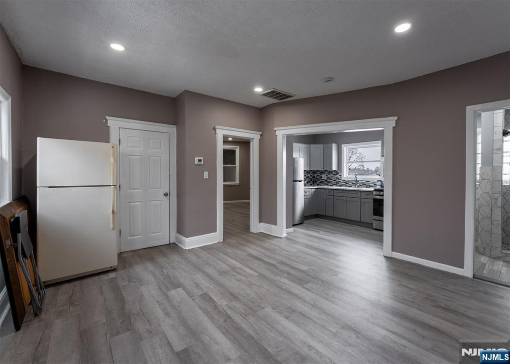 86 Hunter Street Lodi, NJ 07644 - Photo 4 of 18 a view of a livingroom with wooden floor and a refrigerator