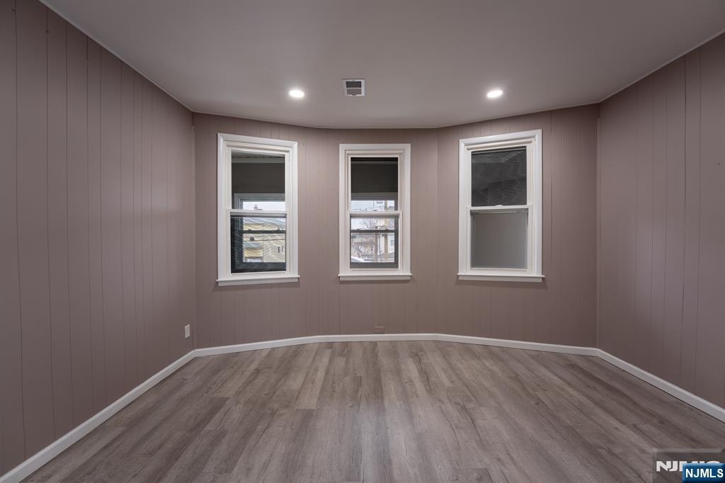 86 Hunter Street Lodi, NJ 07644 - Photo 6 of 18 a view of empty room with wooden floor and fan