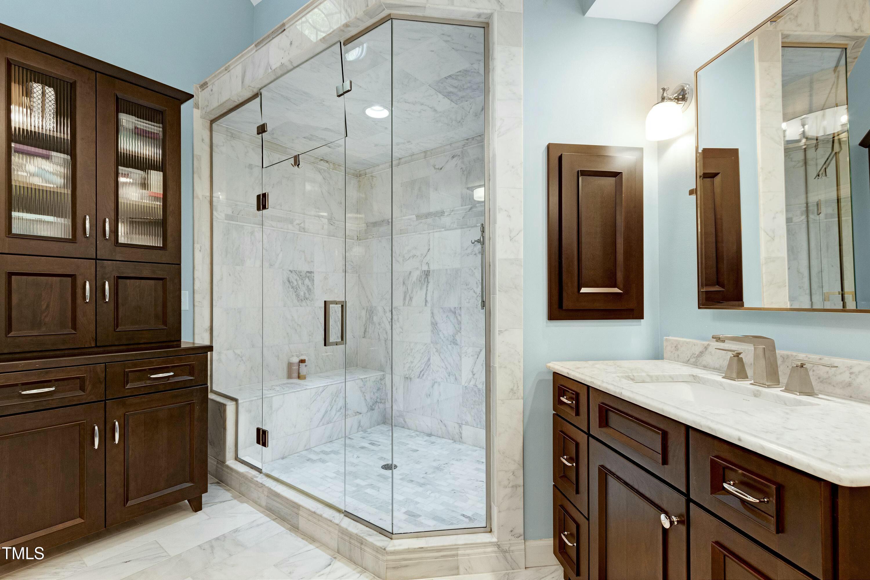 111 Finnway Lane Cary, NC 27519 - Photo 32 of 68 a bathroom with a shower sink and mirror