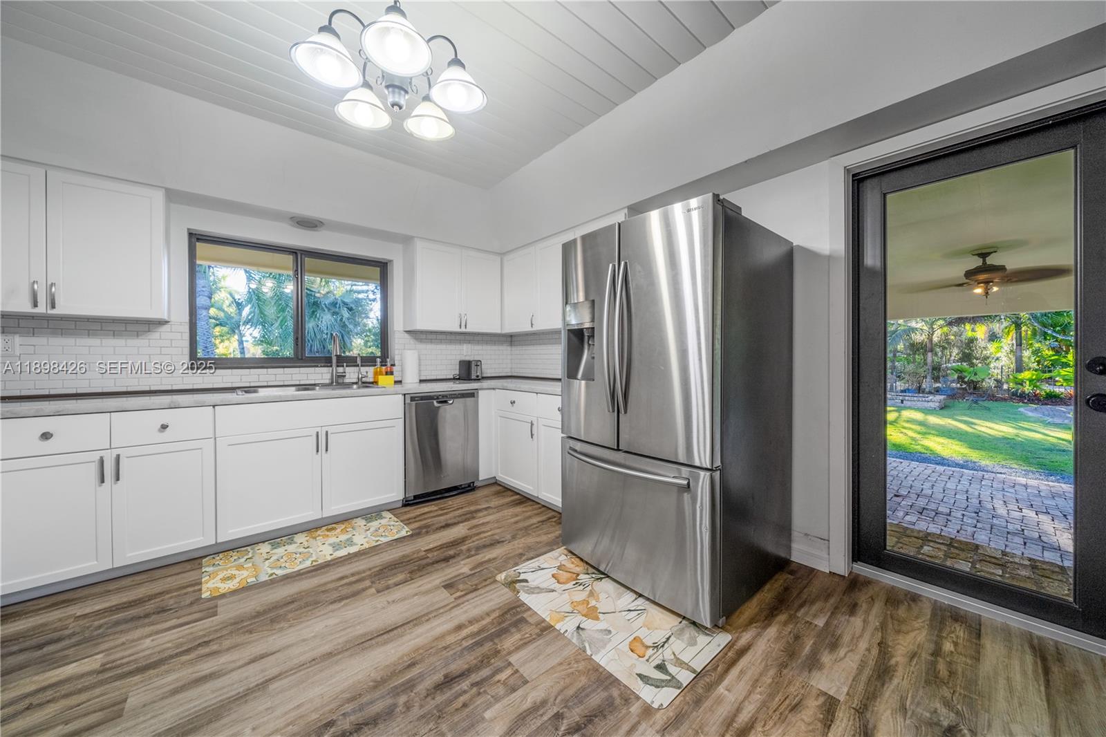 29880 Southwest 183rd Court Homestead, FL 33030 - Photo 11 of 36 a kitchen with a refrigerator a sink cabinets and wooden floor