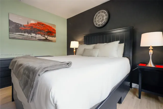 a bedroom with a bed and a lamp on dresser