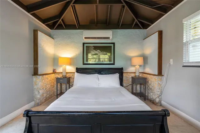 a bed sitting in a bedroom next to a window