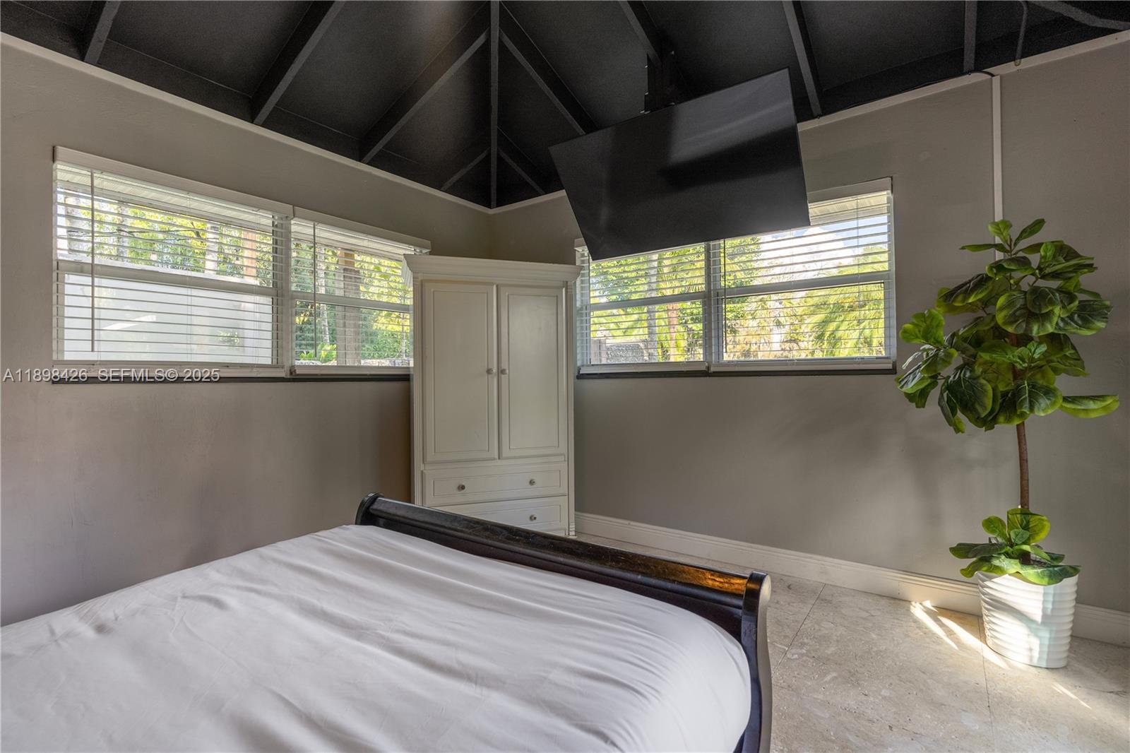 29880 Southwest 183rd Court Homestead, FL 33030 - Photo 20 of 36 a bedroom with a bed and a potted plant