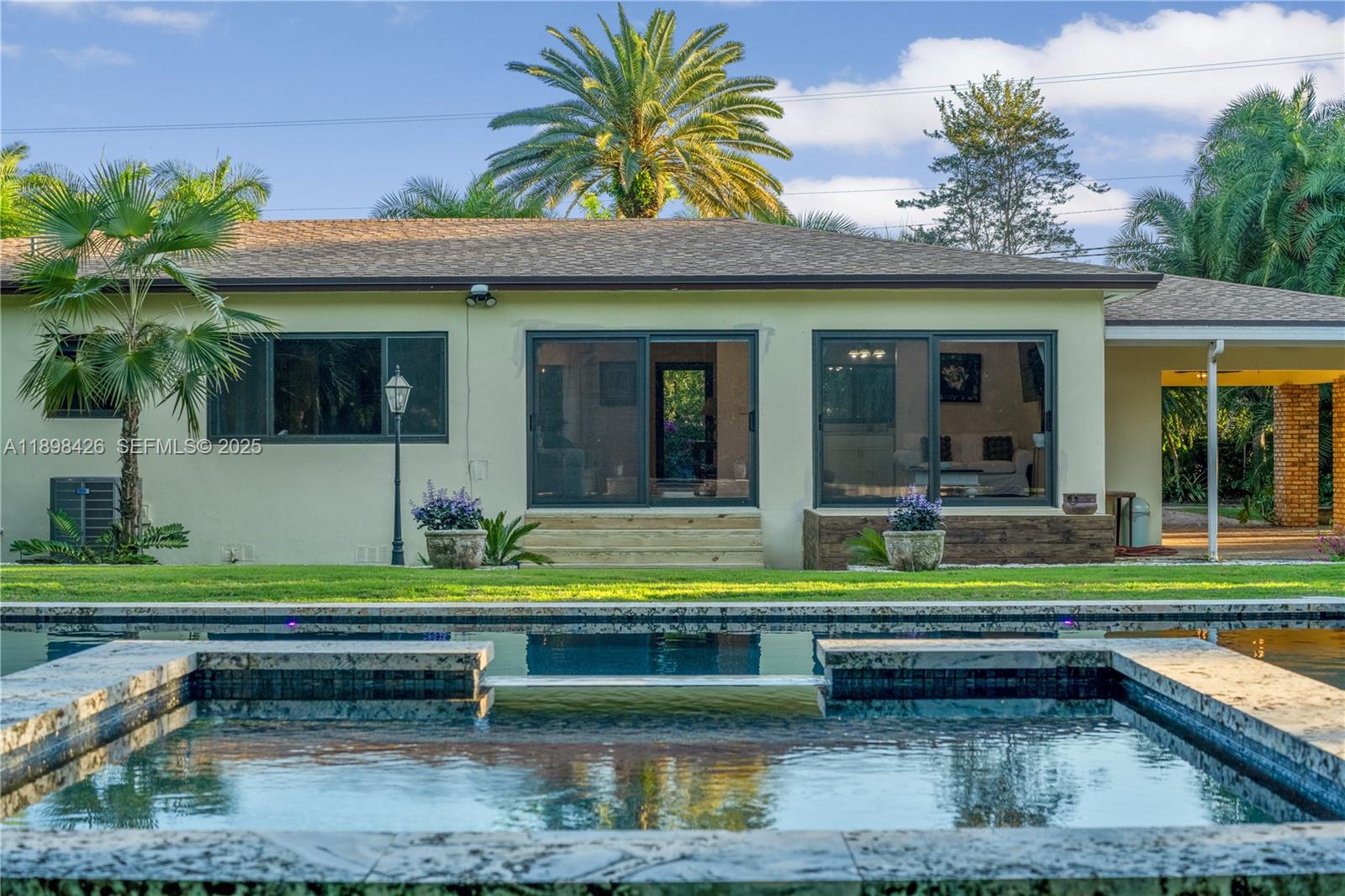 29880 Southwest 183rd Court Homestead, FL 33030 - Photo 2 of 36 a view of swimming pool with lawn chairs and plants