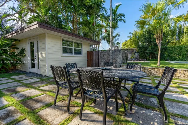a view of backyard with table and chairs and potted plants