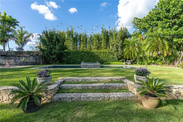 a view of a swimming pool with a garden and trees
