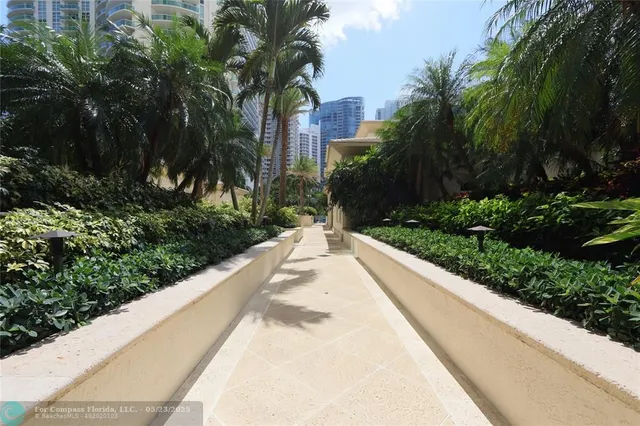 a view of a patio with couches table and chairs with wooden fence and plants