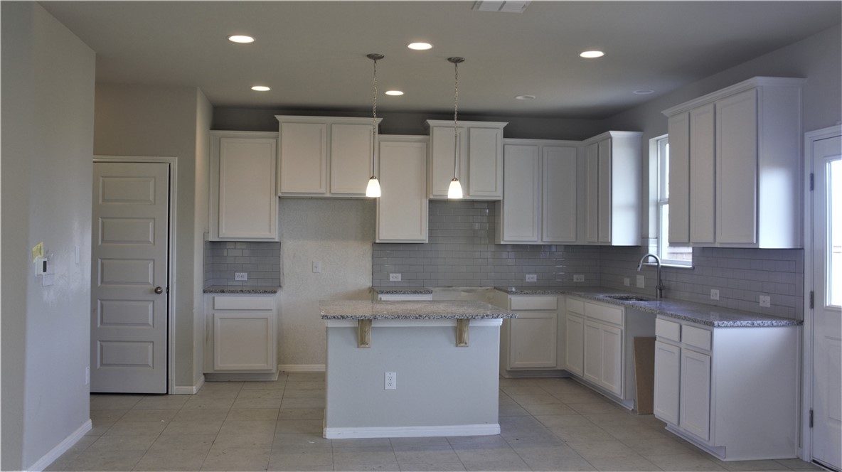 a kitchen with kitchen island a sink stainless steel appliances and cabinets