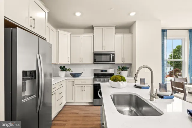a kitchen with stainless steel appliances granite countertop a sink refrigerator and cabinets