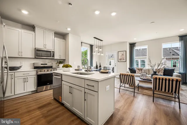 a kitchen with white cabinets and chairs