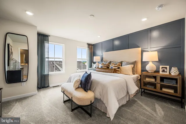 a spacious bedroom with a bed a couch and large window