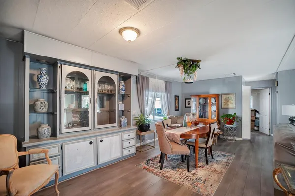 a view of a dining room with furniture a chandelier and wooden floor