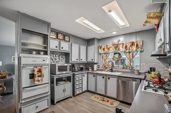 a kitchen with stainless steel appliances a sink a stove a refrigerator cabinets and a counter top space