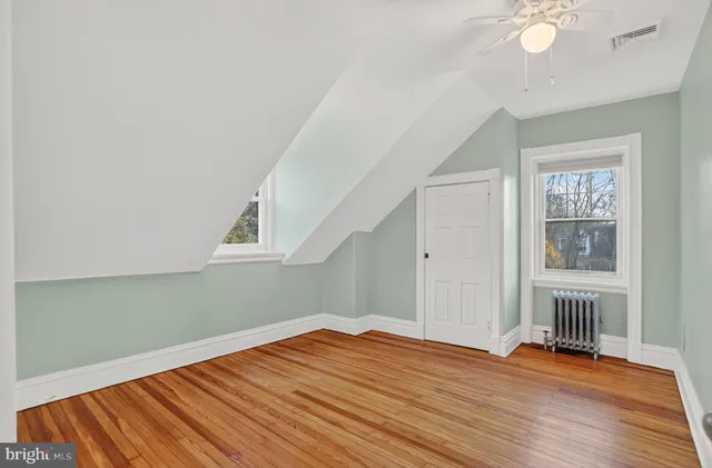 a view of empty room with wooden floor and window