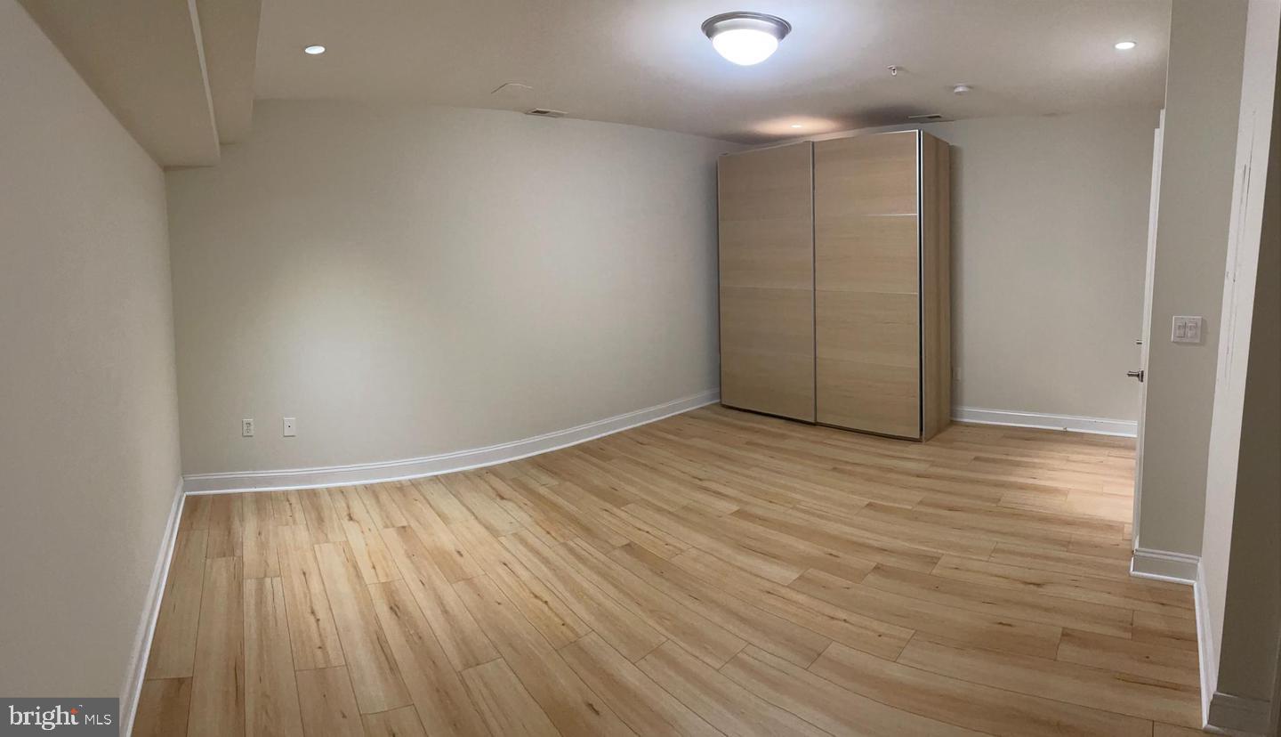 3925 Fulton Street Northwest, Unit 5 Washington, DC 20007 - Photo 12 of 19 an empty room with wooden floor and windows