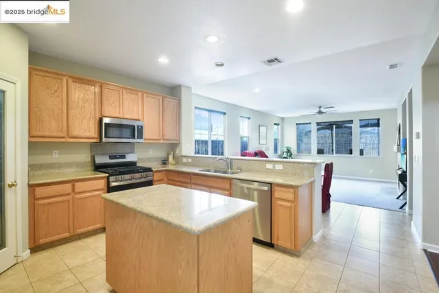 a kitchen with stainless steel appliances granite countertop a refrigerator a stove top oven a sink and dishwasher