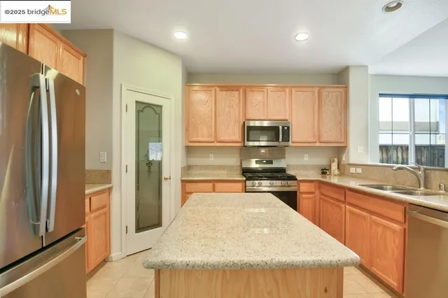 a kitchen with furniture a sink a window and stainless steel appliances