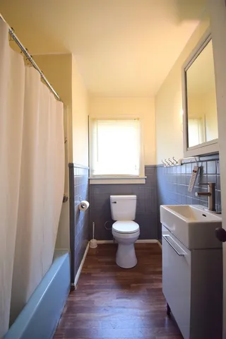 a bathroom with a sink a toilet and a window