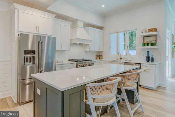 a kitchen with granite countertop a table chairs stainless steel appliances and wooden cabinets
