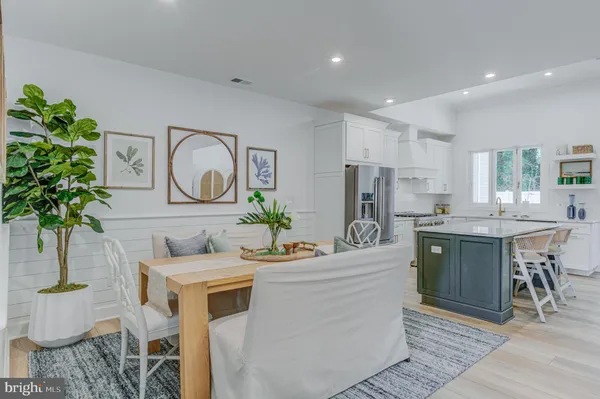 a kitchen with stainless steel appliances kitchen island granite countertop a stove a sink a dining table and chairs