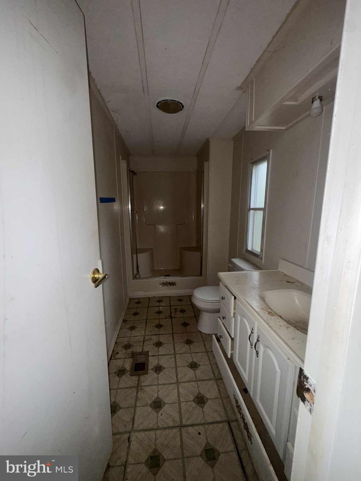 31061 Vacation Road Millsboro, DE 19966 - Photo 10 of 12 a bathroom with a granite countertop sink a toilet and shower