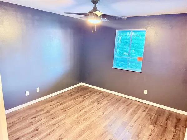 a view of empty room with window and wooden floor