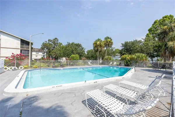 a view of a swimming pool with a yard and sitting area