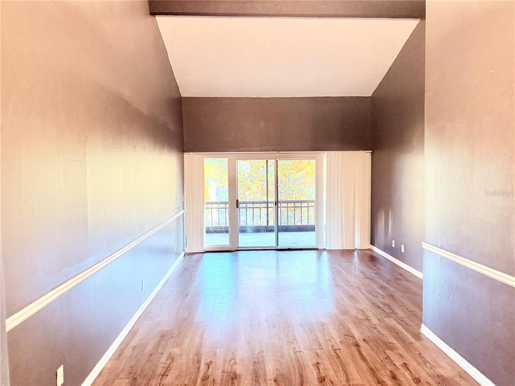 6519 West Newberry Road, Unit 211 Gainesville, FL 32605 - Photo 6 of 20 a view of an empty room with wooden floor and a window