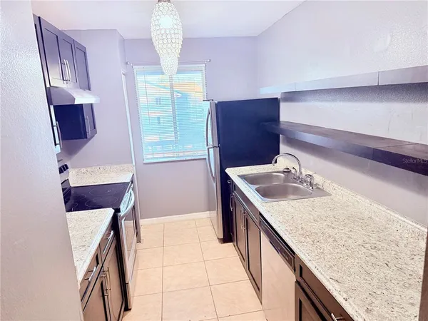a kitchen with a sink a stove and a microwave