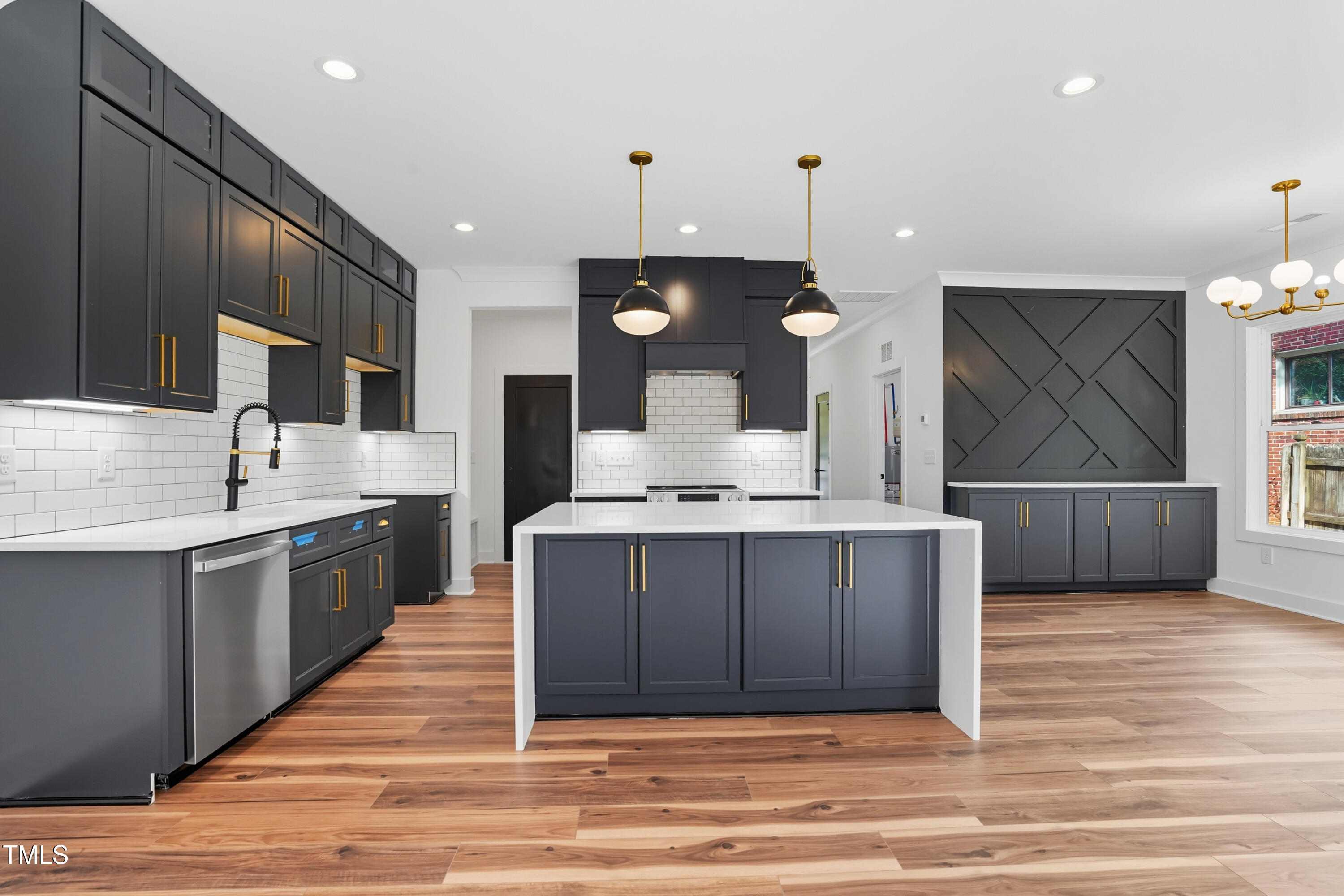 304 North King Charles Road, Unit 102 Raleigh, NC 27610 - Photo 14 of 30 a large kitchen with a large counter top a sink stainless steel appliances and cabinets