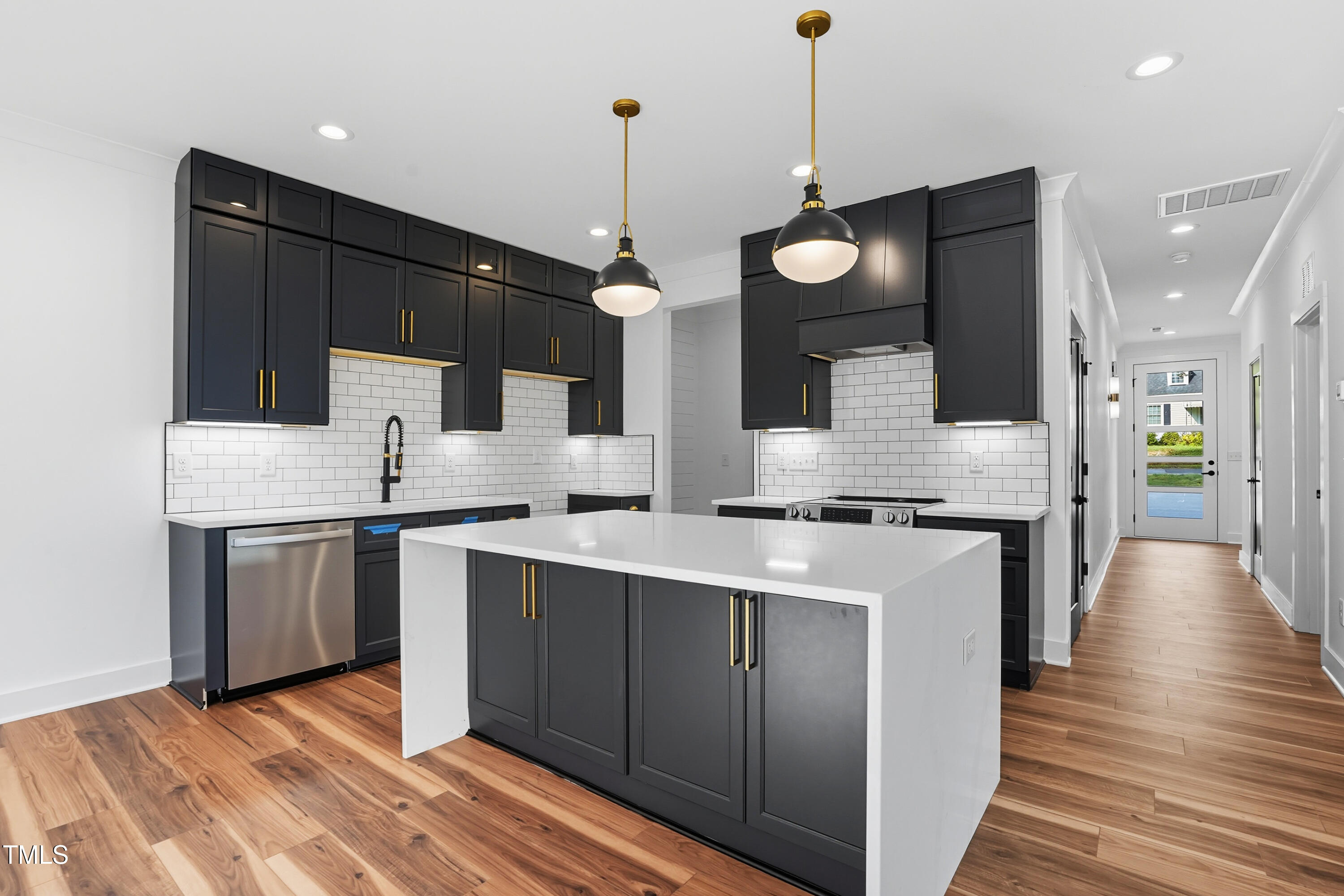 304 North King Charles Road, Unit 102 Raleigh, NC 27610 - Photo 15 of 30 a kitchen with stainless steel appliances granite countertop a sink a stove and a wooden floors