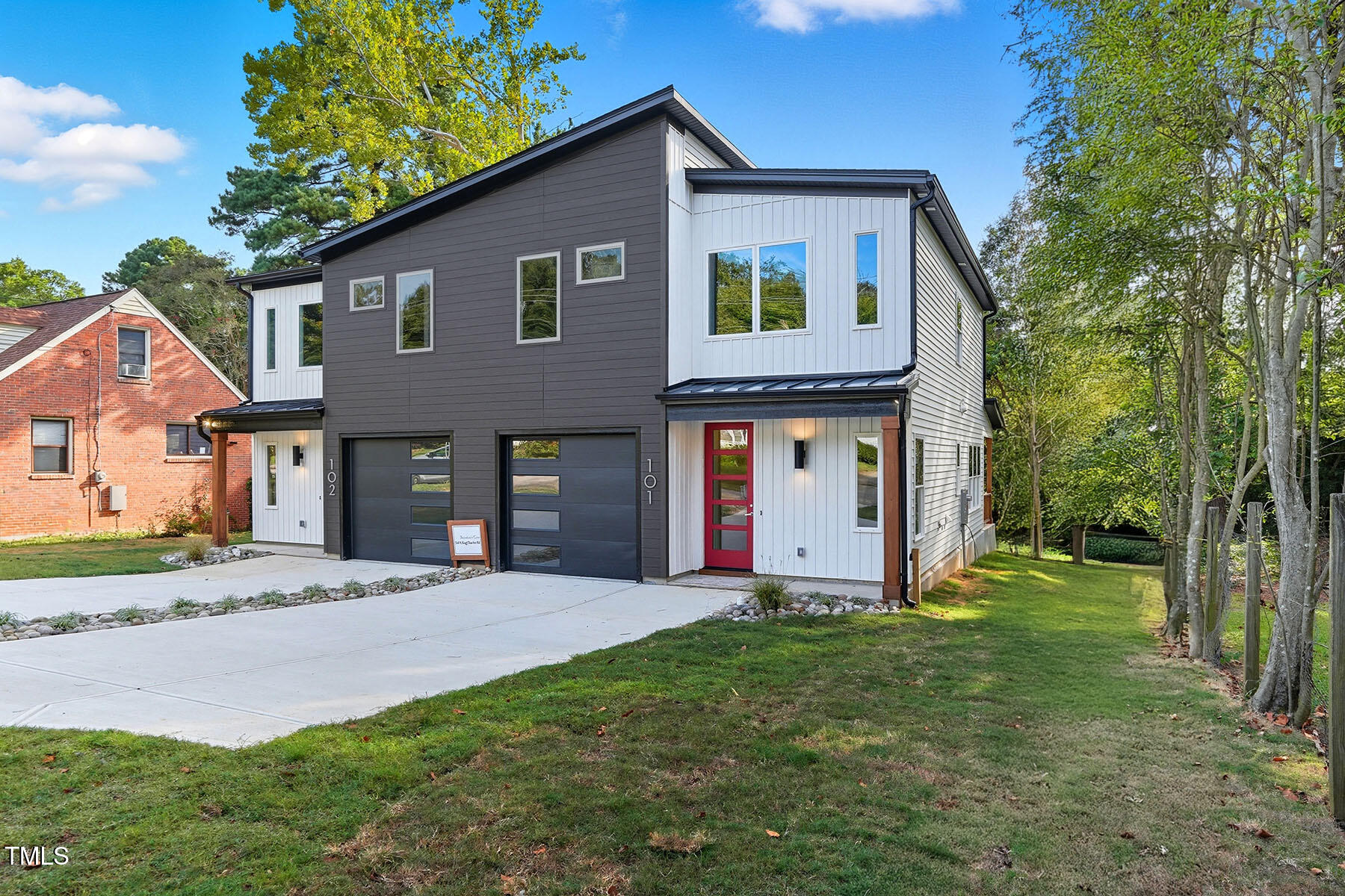 304 North King Charles Road, Unit 102 Raleigh, NC 27610 - Photo 2 of 30 a view of a yard in front of a brick house with a large tree