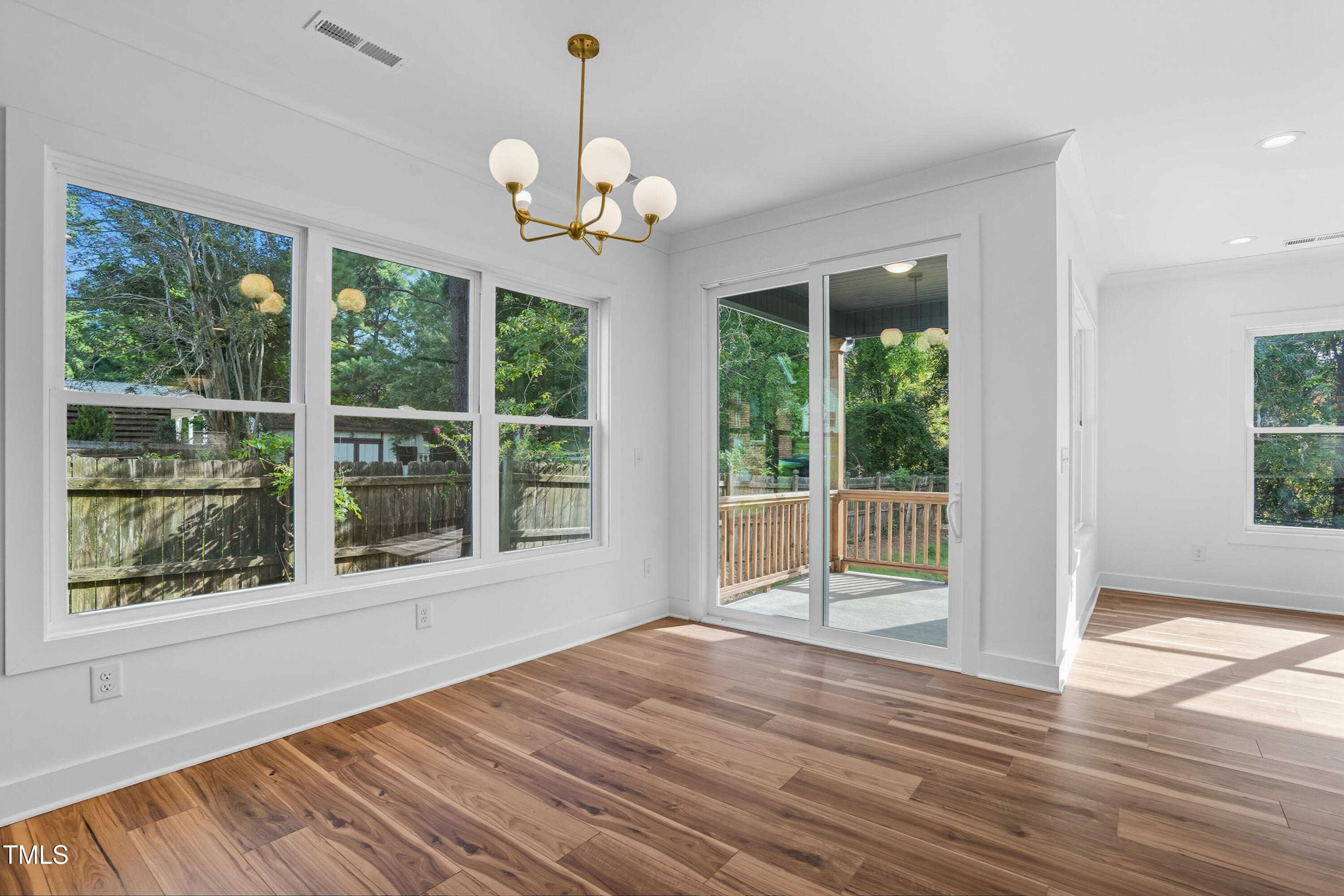 304 North King Charles Road, Unit 102 Raleigh, NC 27610 - Photo 8 of 30 a view of an empty room with wooden floor and a window