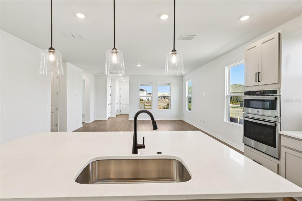 6673 Wake Street St. Cloud, FL 34771 - Photo 12 of 44 a kitchen with kitchen island a sink stainless steel appliances and a counter top space