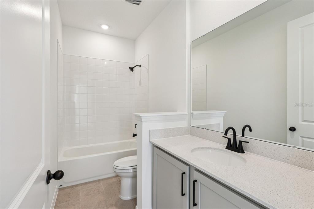 6673 Wake Street St. Cloud, FL 34771 - Photo 18 of 44 a bathroom with a sink a toilet and a tub